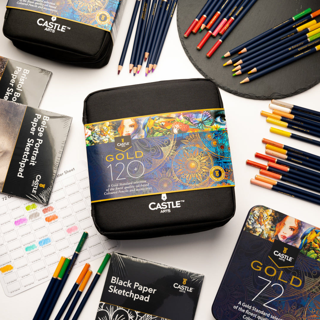 Castle Gold zip-case pencil set surrounded by Castle Gold colored pencils, sketch pads and a Castle Gold display tin.